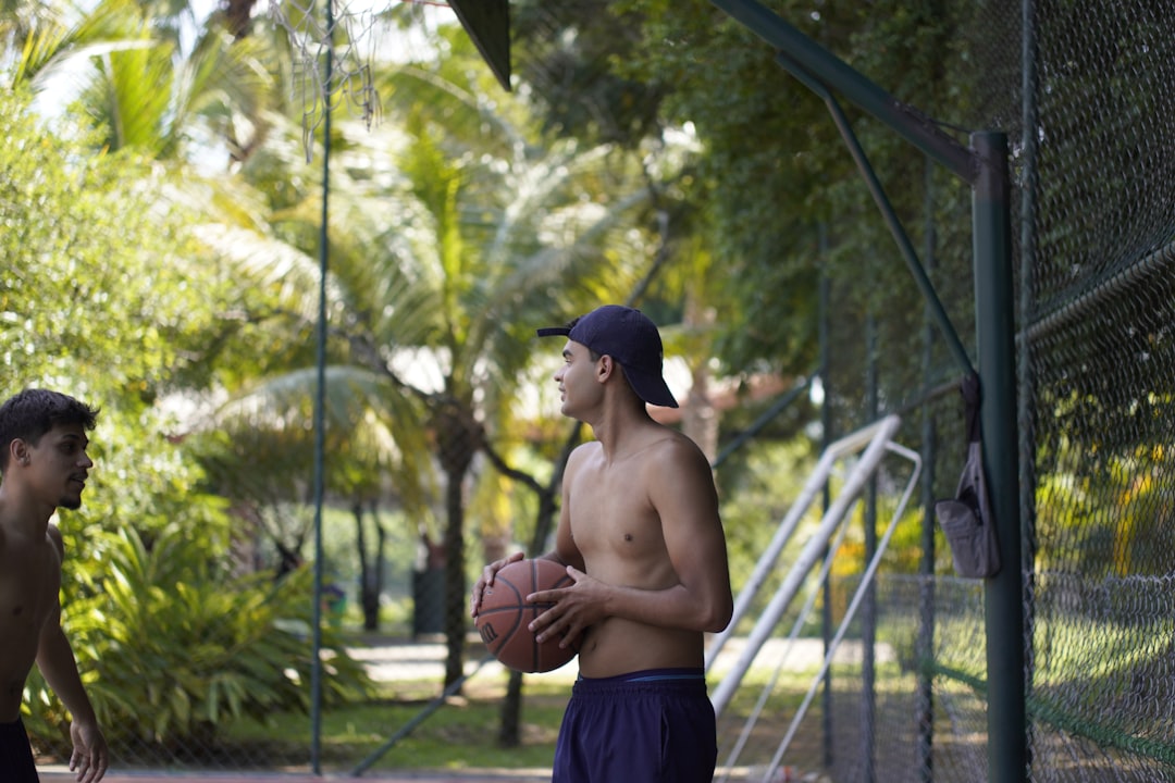 A young man with a basketball on an outdoor court